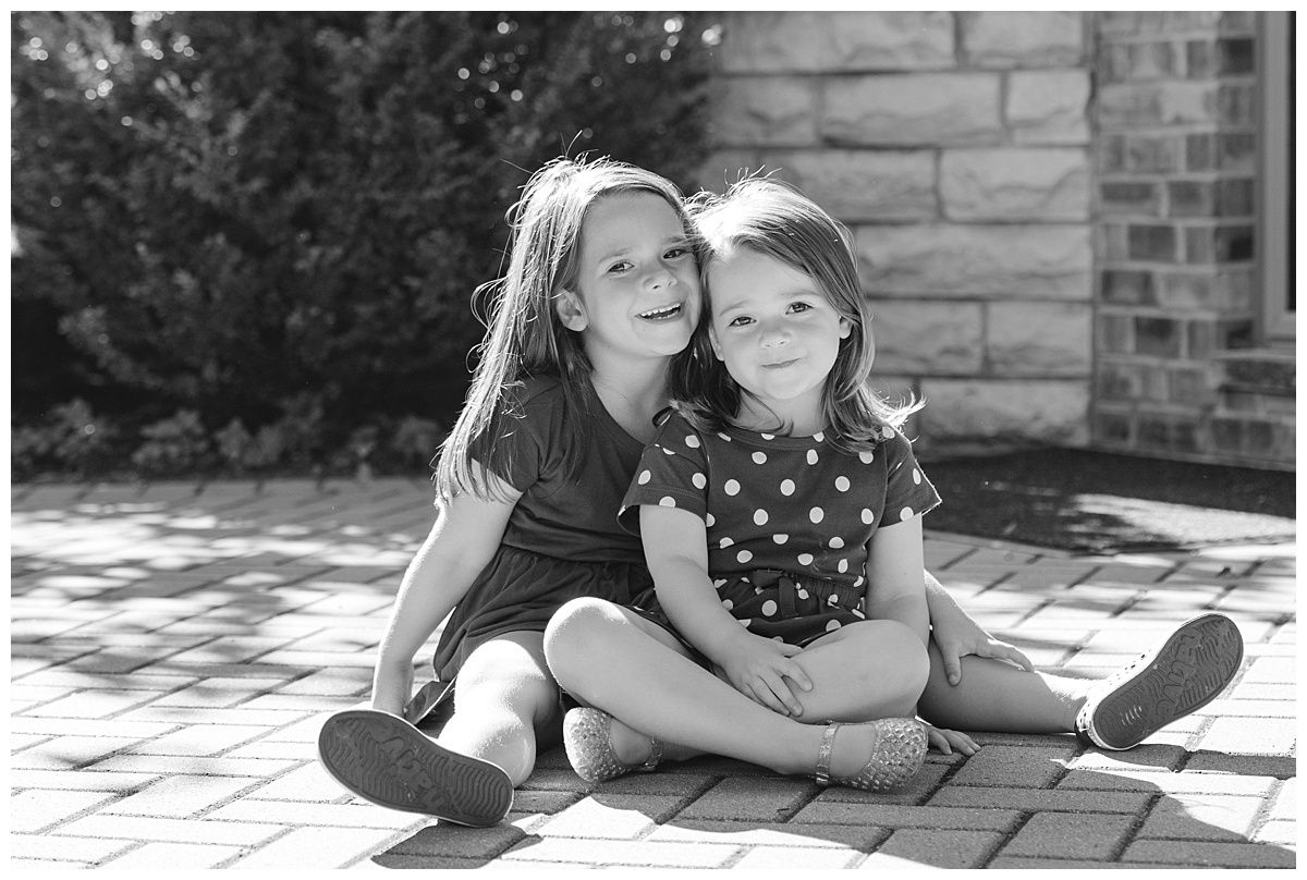 Granddaughters sitting in the sun and smiling