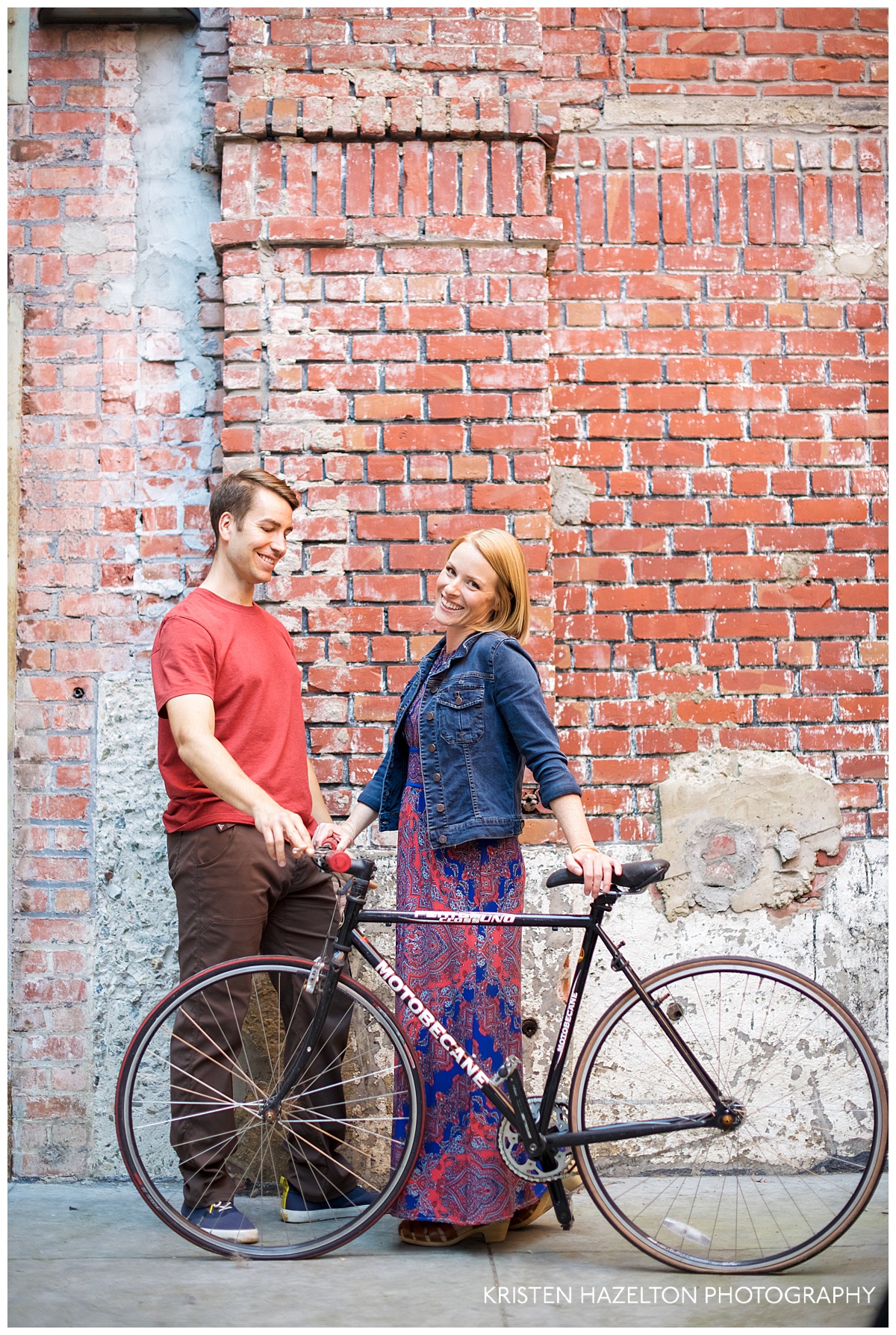 Engaged couple posing with a road bike