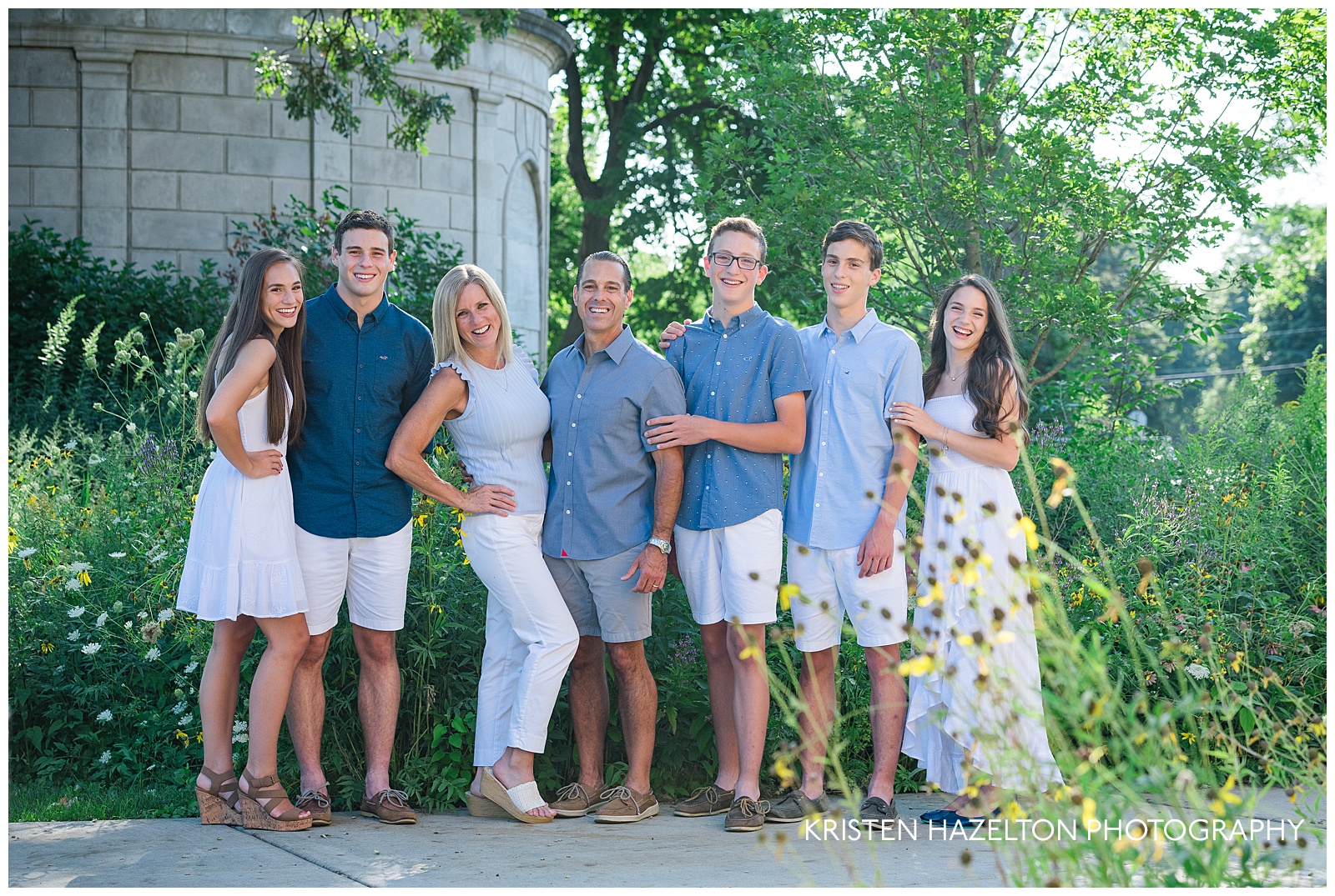 A family of seven posing with native midwest flowers for river forest il family photos