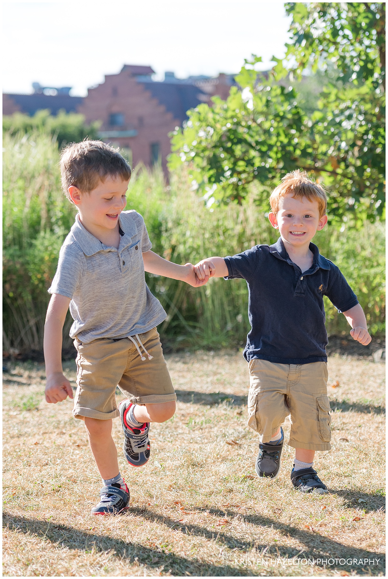 Two little boys running toward the camera and smiling for their Scoville Park family photos