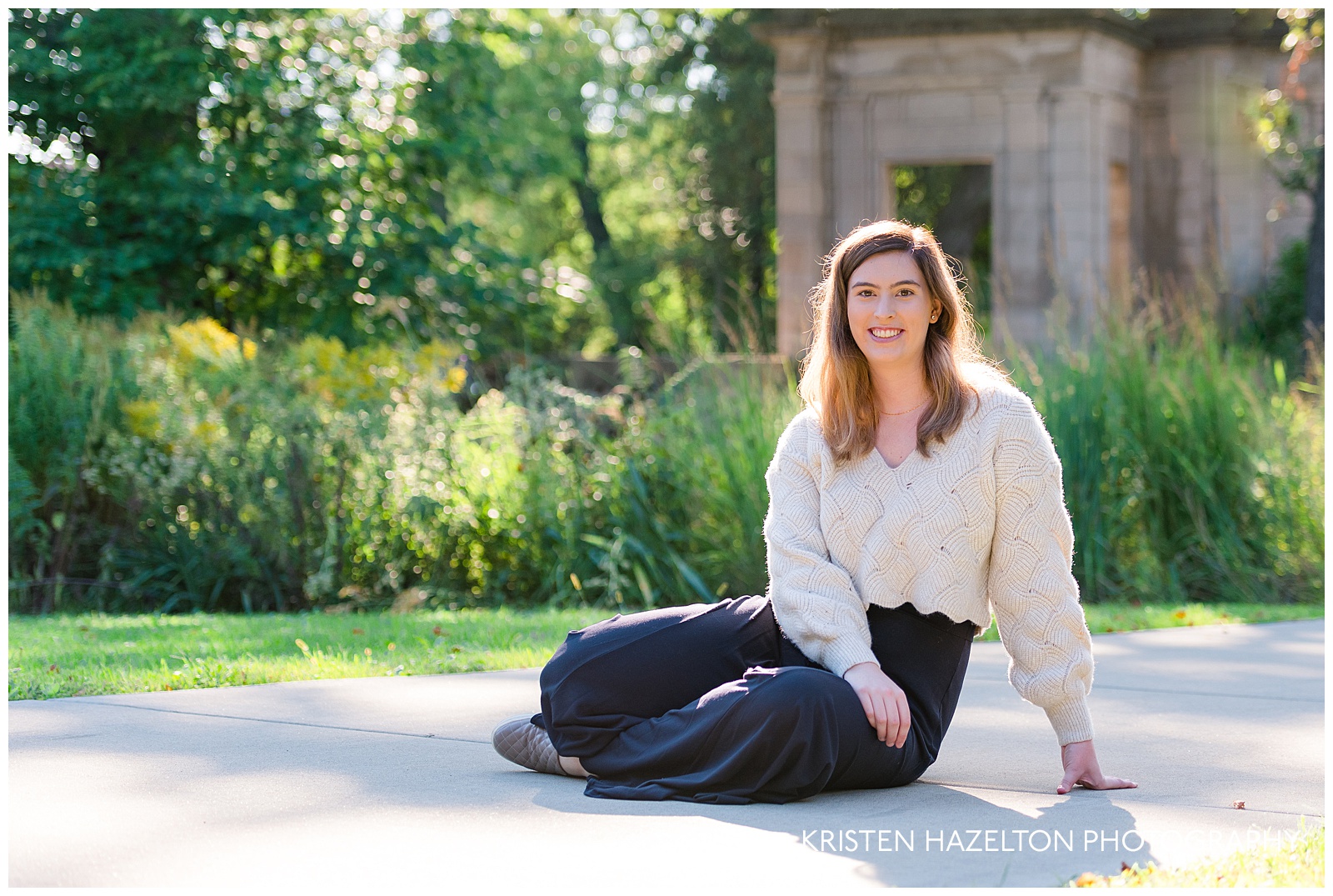 College graduate senior photos of a woman sitting on a path at Cummings Square in River Forest, IL, gorgeously backlit