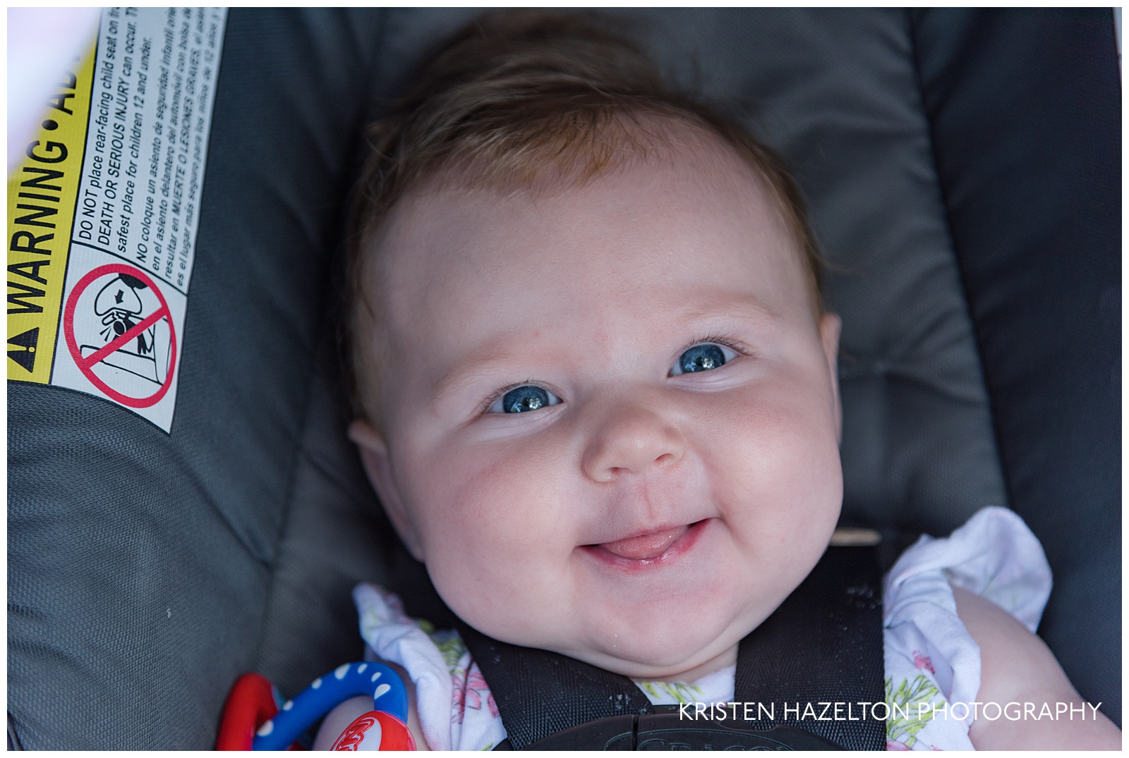 Cheerful four month old in a carseat