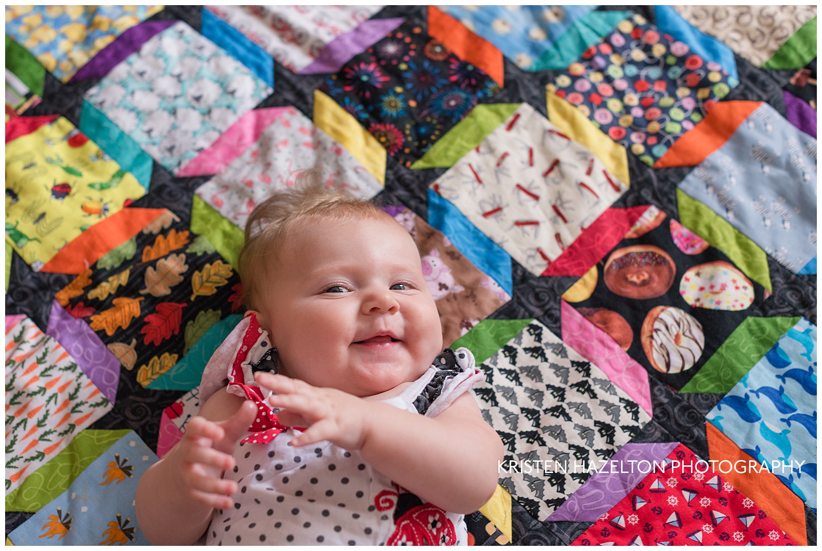 Happy five-month baby on a colorful quilt