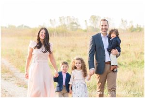 Family of five walking in a meadow