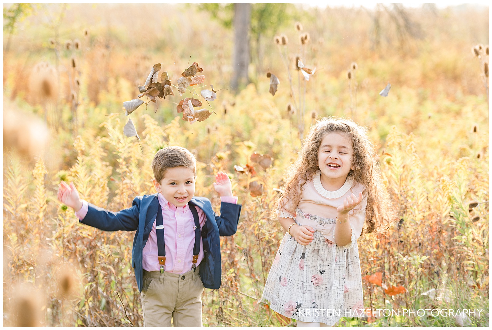 Portraits of a brother and sister throwing leaves in the air