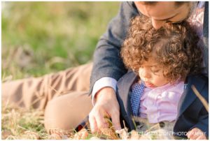 father playing with his baby son in a field