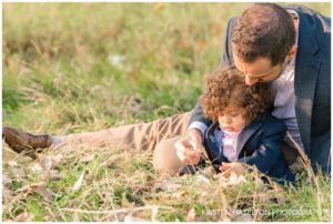 father playing with his baby son in a field