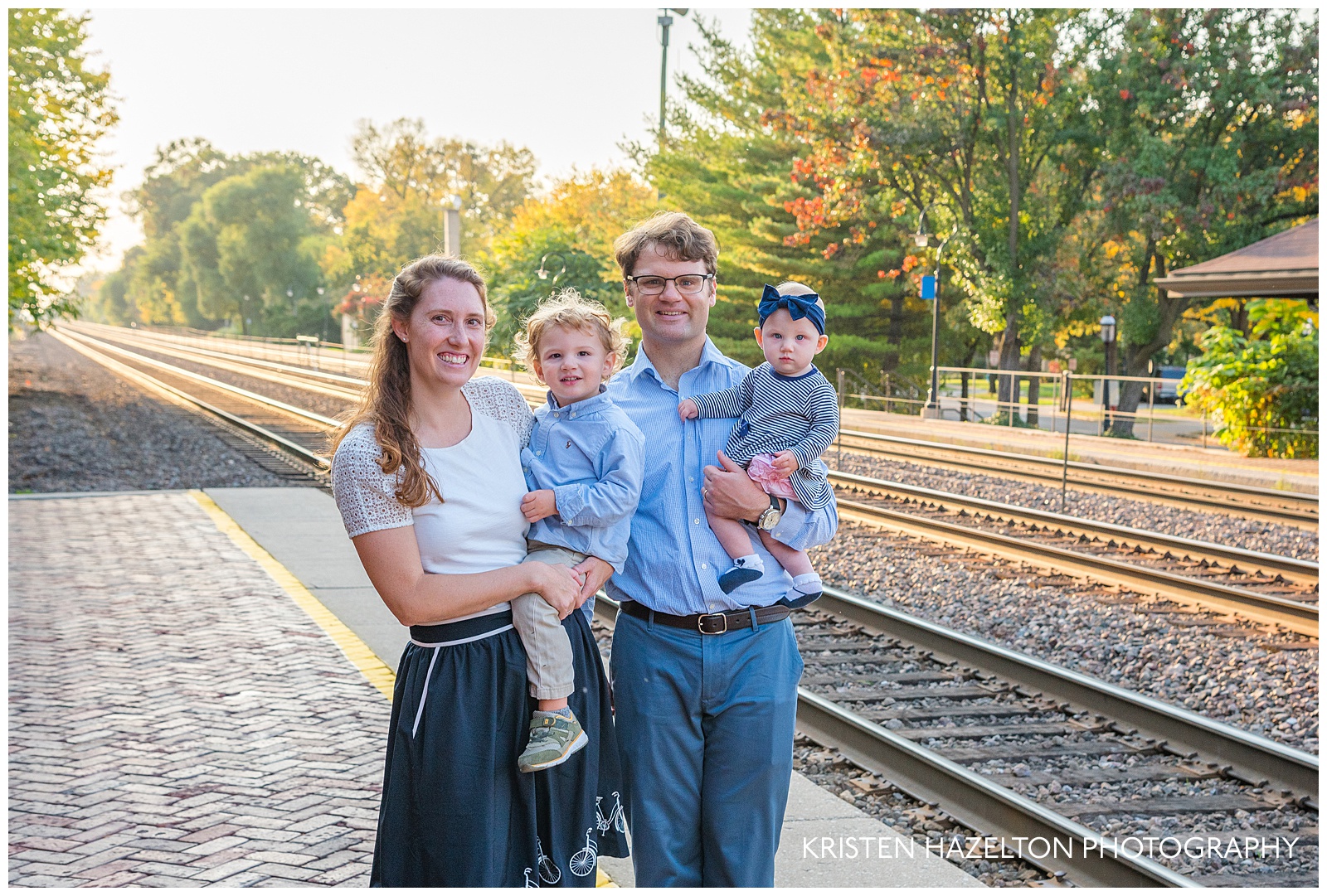 Family portrait of four at a train station