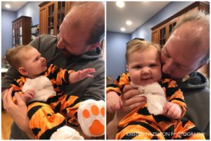Father holding baby dressed as a tiger
