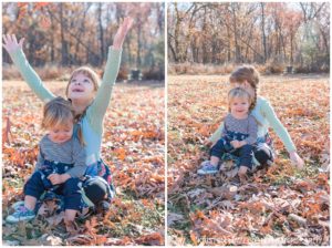 Fall family portraits of Two sisters sitting and throwing leaves together
