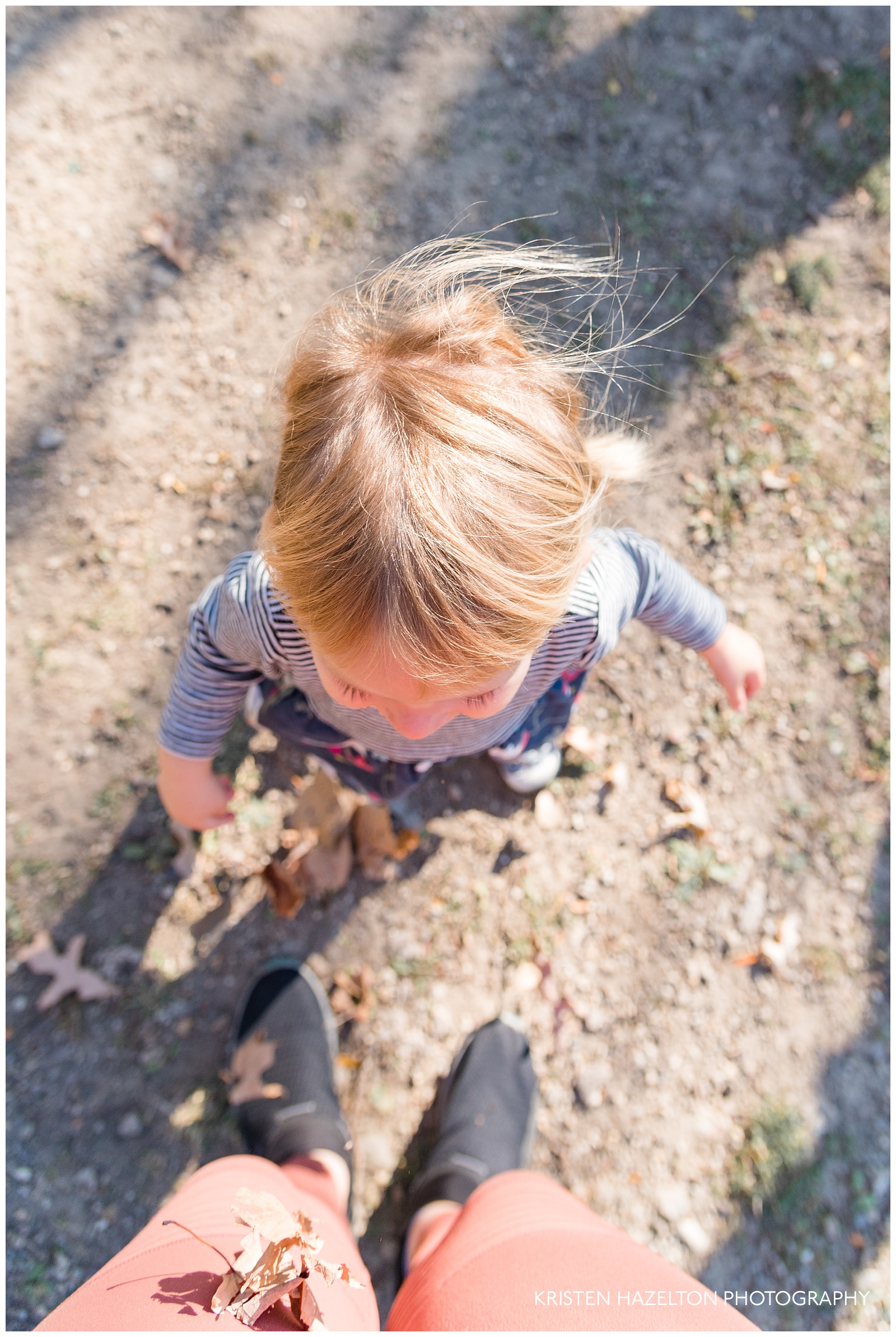 Toddler throwing leaves at the photographer