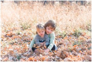 Family portraits of Two sister throwing leaves together