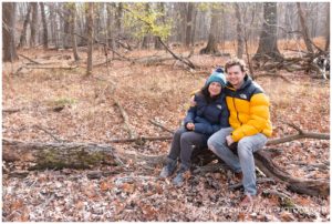 Candid portrait of a young couple in winter jackets in the woods