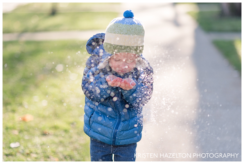 young boy blowing artificial snow