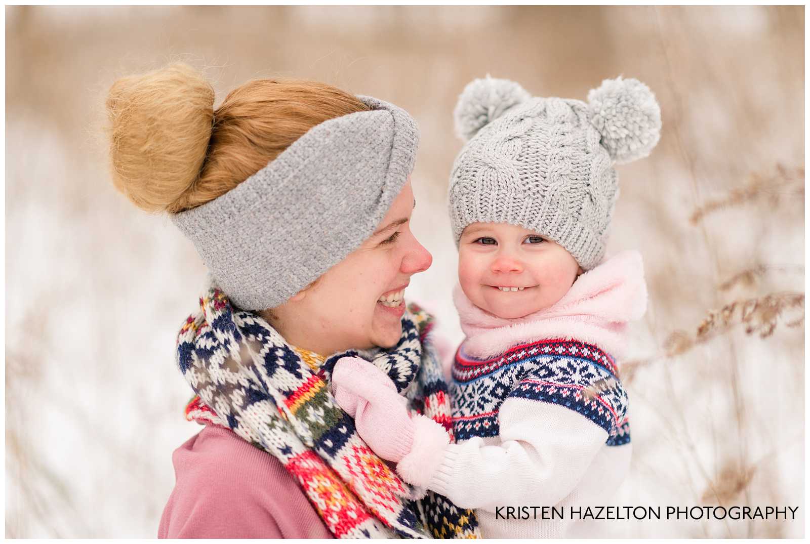 Snow photo of a Mom grinning at her toddler daughter