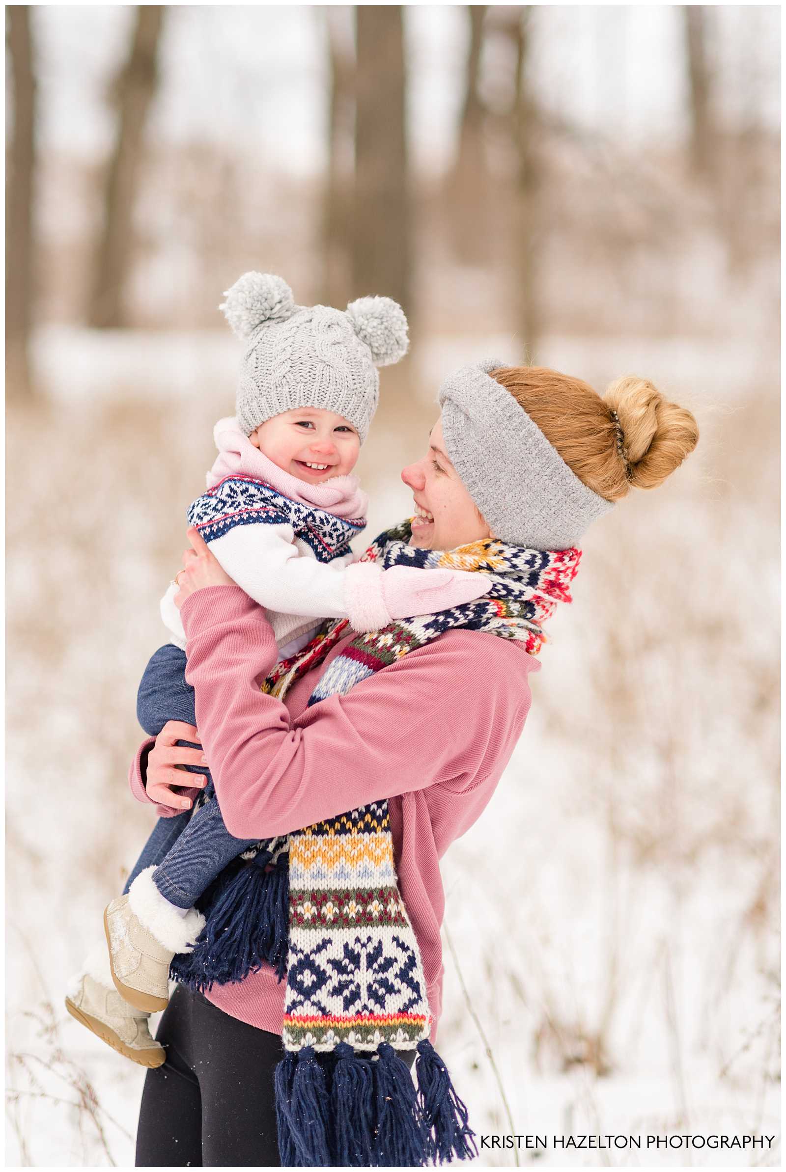Mom hugging her toddler daughter in the snow