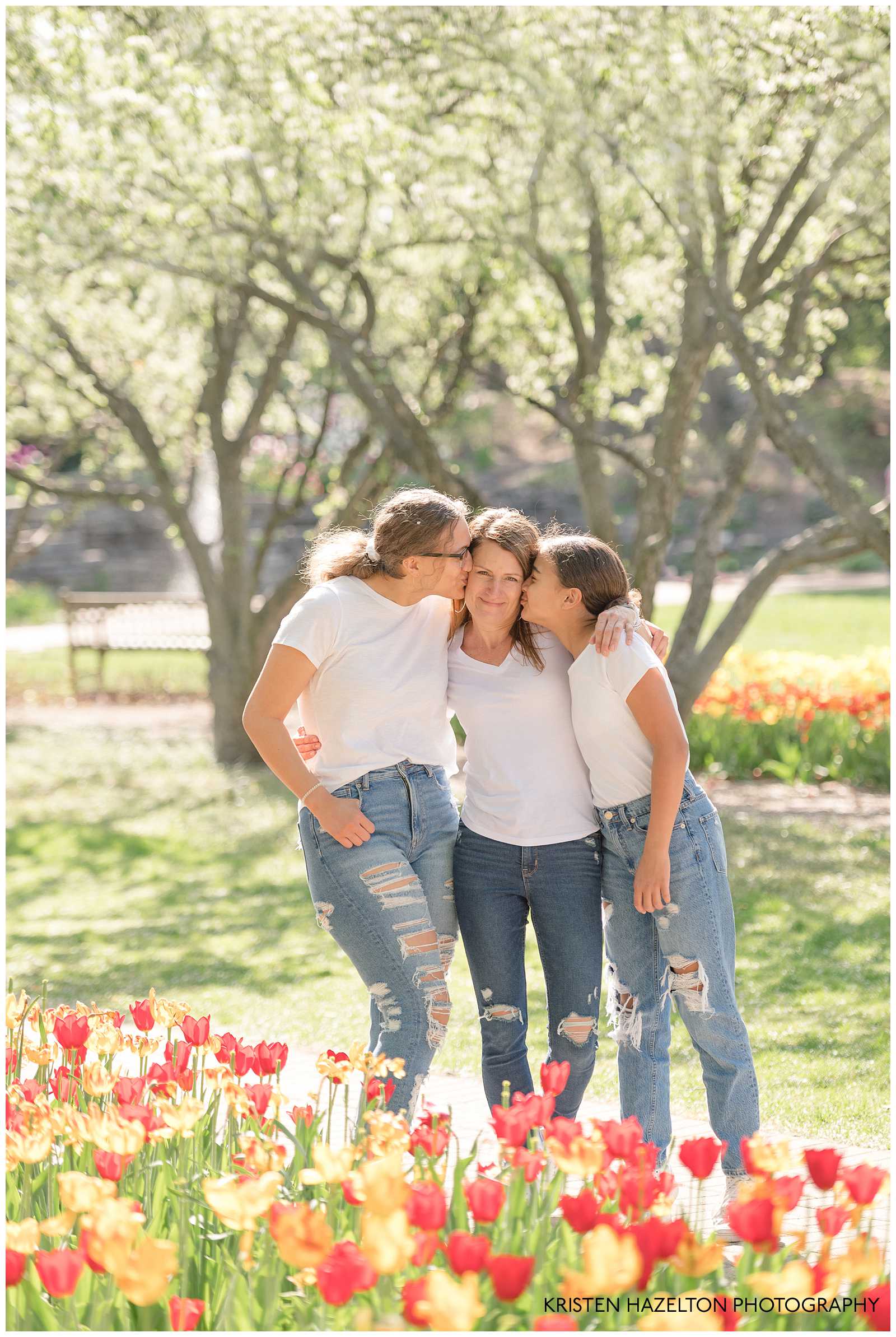 Two teenage daughters kissing their mom's cheek by Lombard, IL photographer Kristen Hazelton