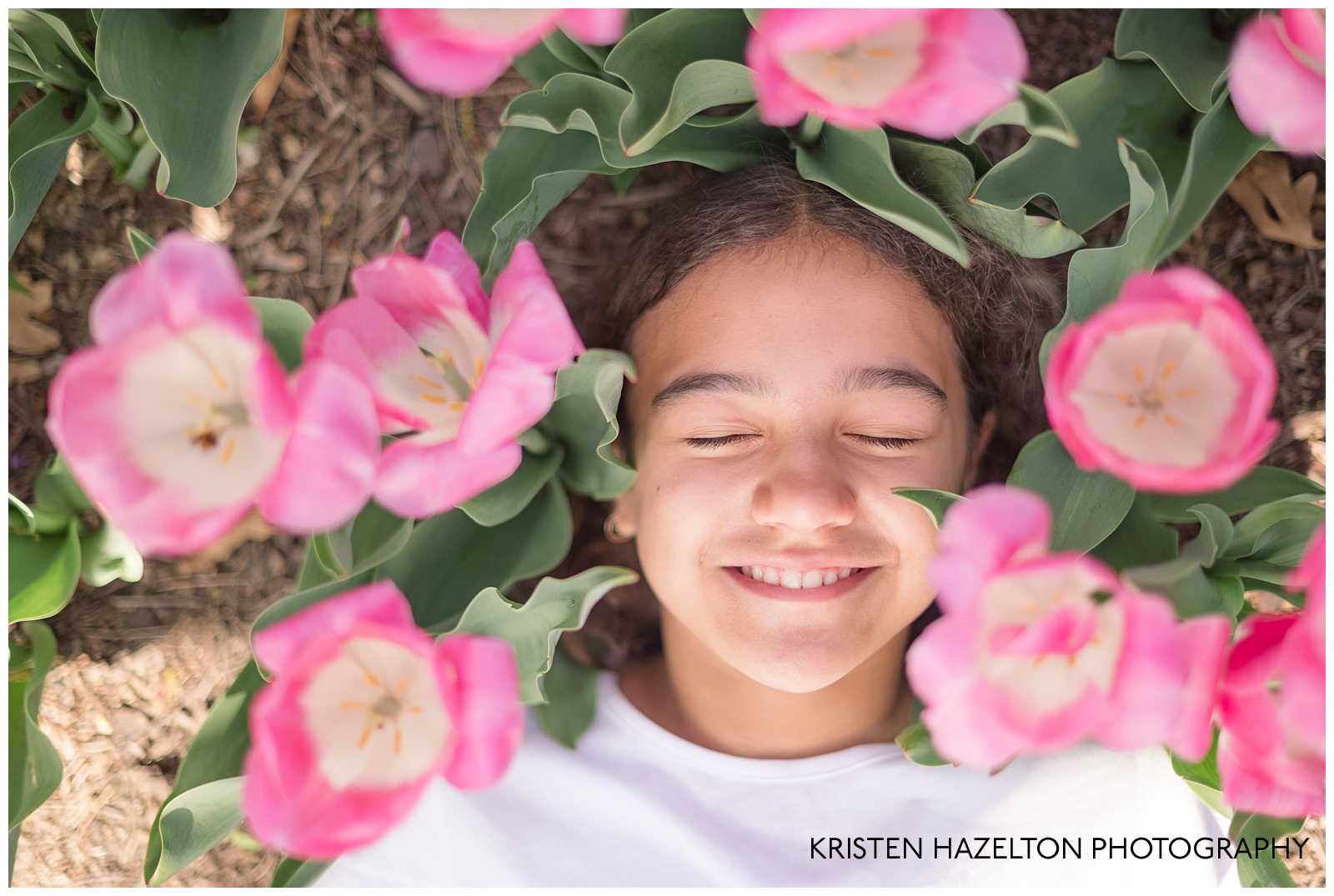 Girl resting in a bed of pink tulips by Lombard, IL photographer Kristen Hazelton