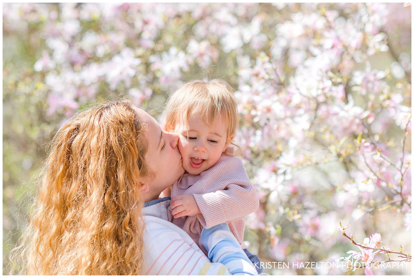 Redheaded woman kissing her toddler daughter a a motherhood mini photoshoot