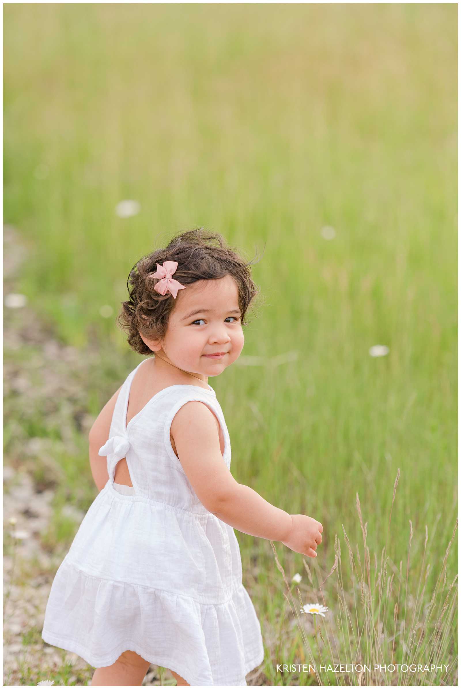 Little girl playing in a meadow by Forest Park, IL photographer Kristen Hazelton