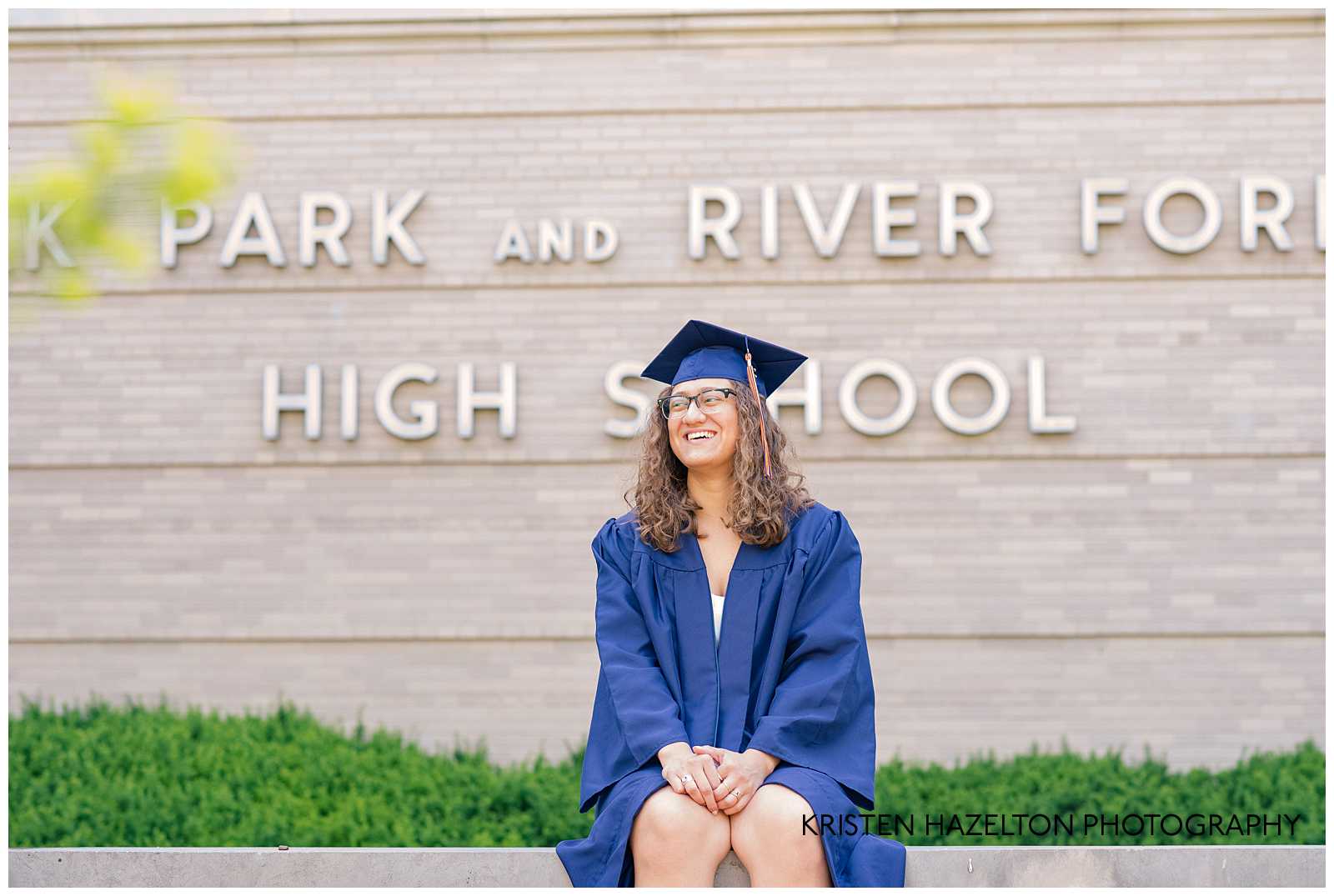 OPRFHS Senior Photos of a female graduate in front of a sign that reads Oak Park and River Forest High School