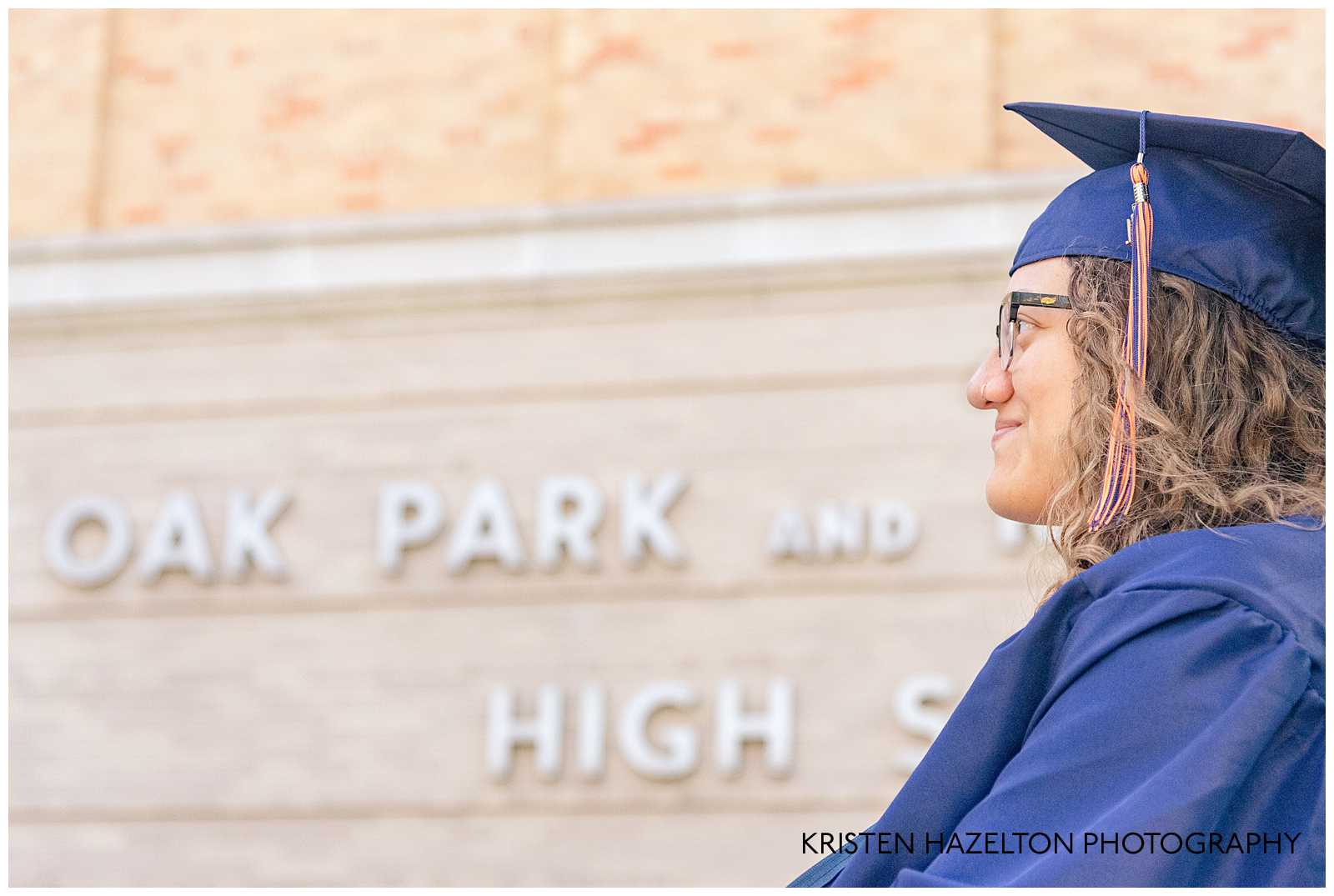 Photo of a the profile of a high school graduate in front of her school