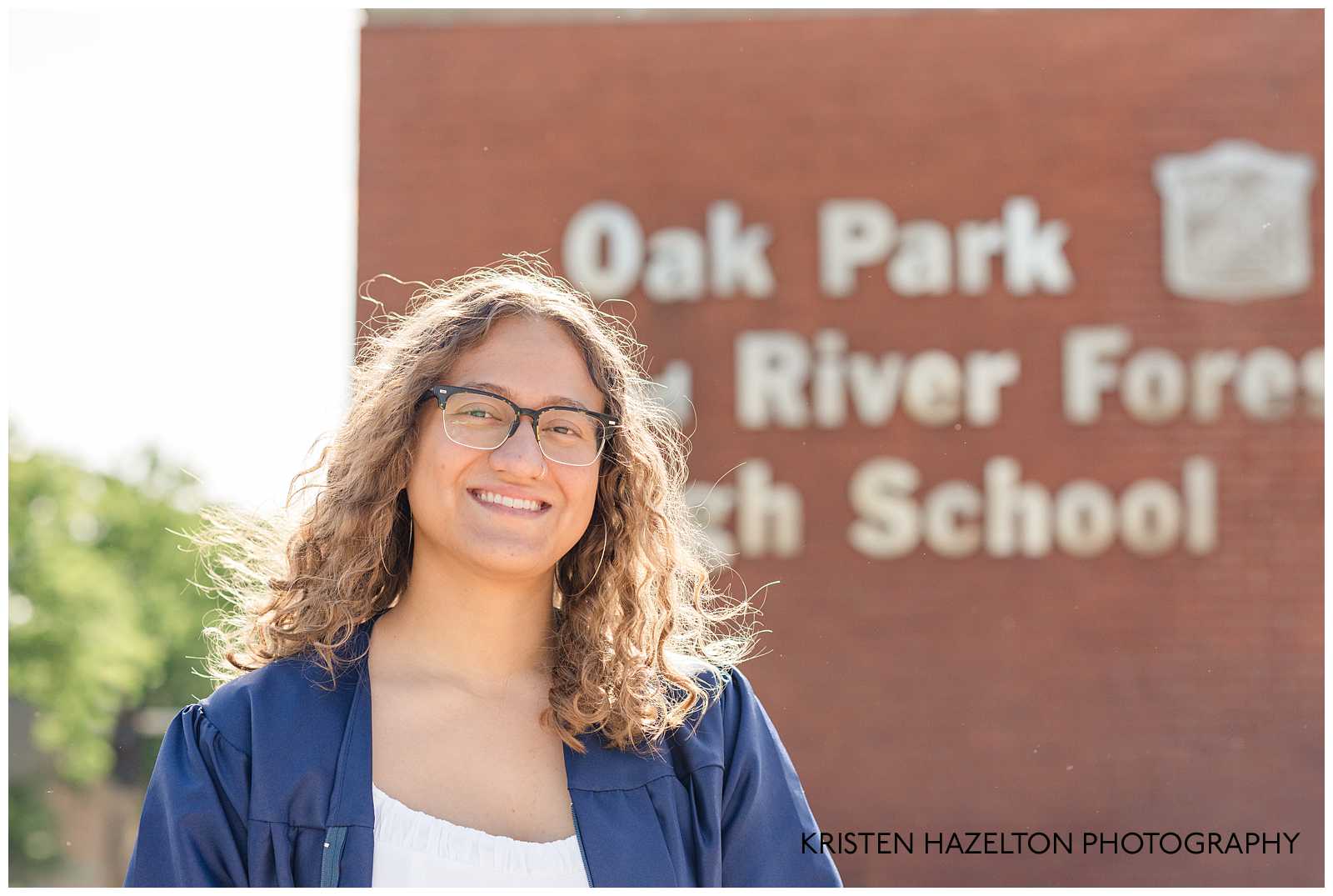 OPRFHS female graduate smiling in front of the school parking garage