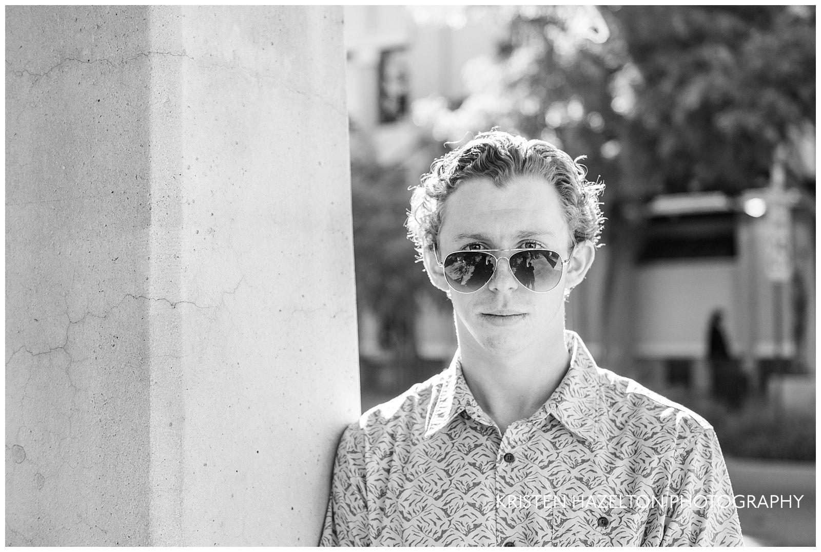 Black and white high school senior guy looking over aviator sunglasses 