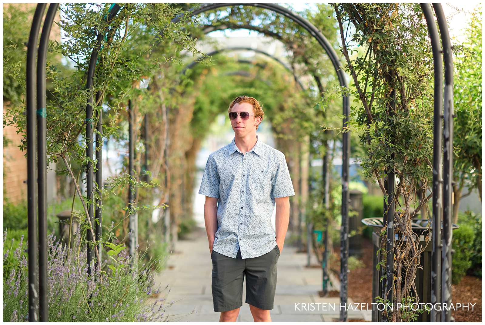 Male high school senior standing in the middle of an arbor walkway