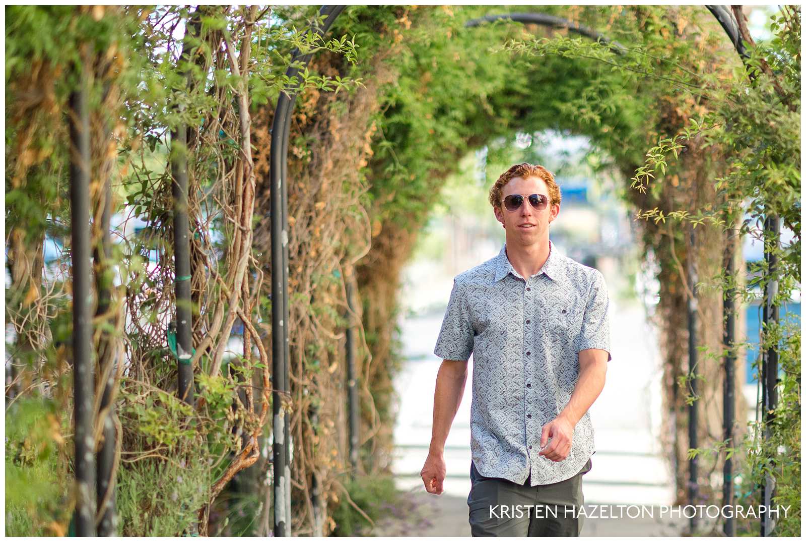 male high school senior walking through an arbor walkway in downtown Livermore