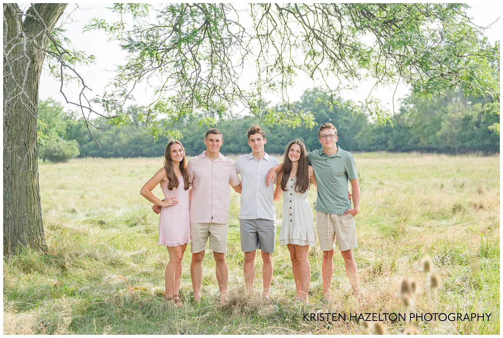 Five teenage siblings standing in a field for family portraits