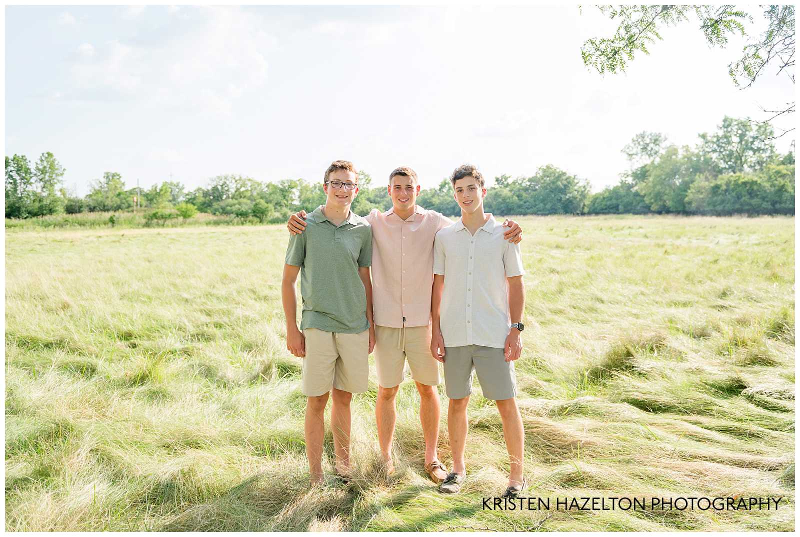 Three teenage brothers standing together in a field