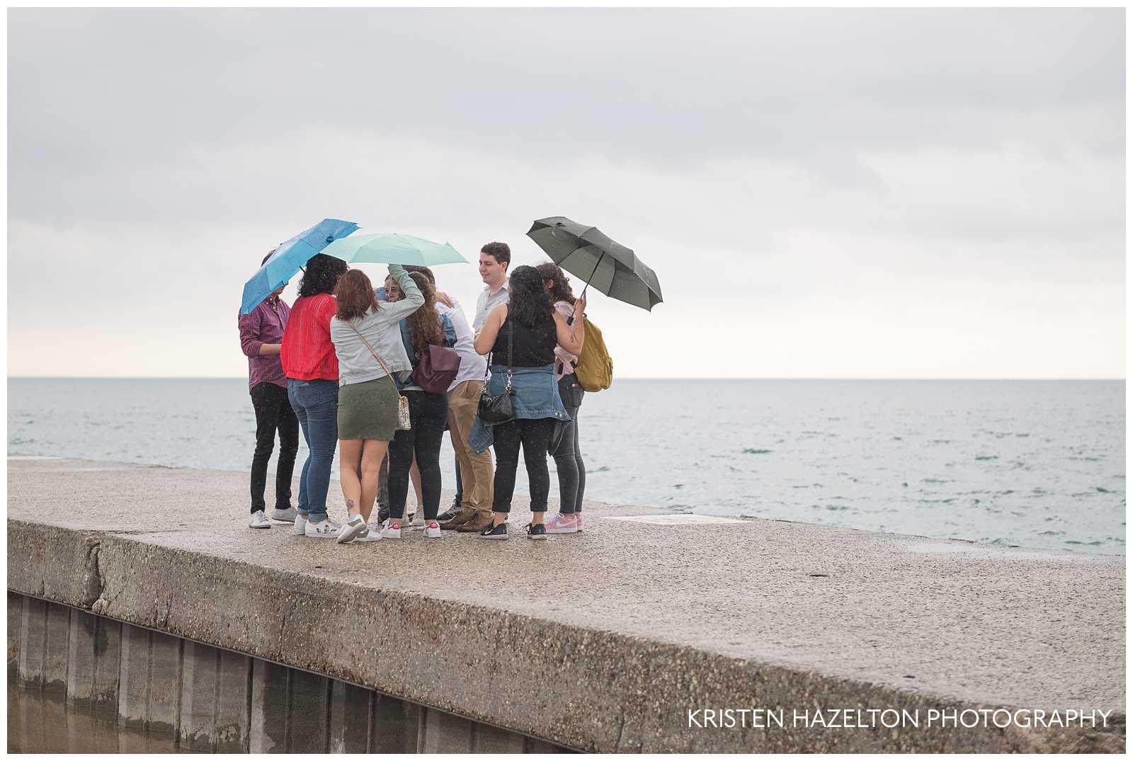 Friends congratulating a newly engaged couple during a stormy surprise proposal at North Avenue Beach