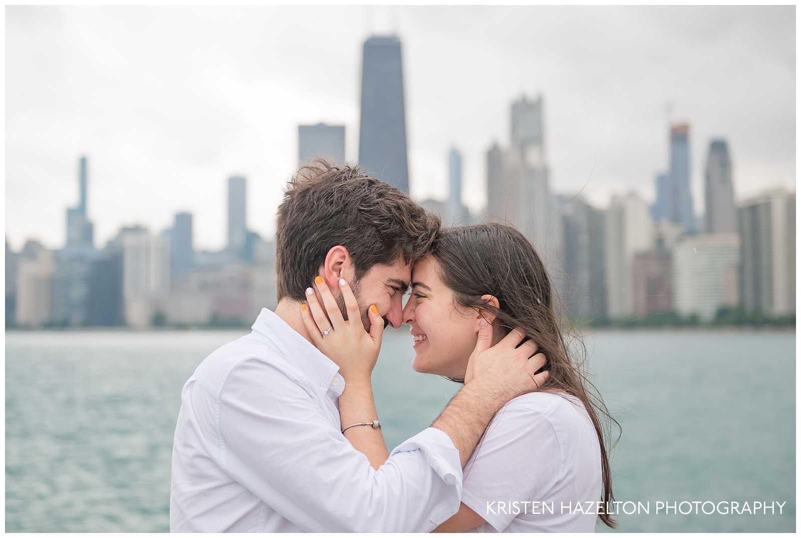 Newly engaged couple touching noses in front of the Chicago skyline