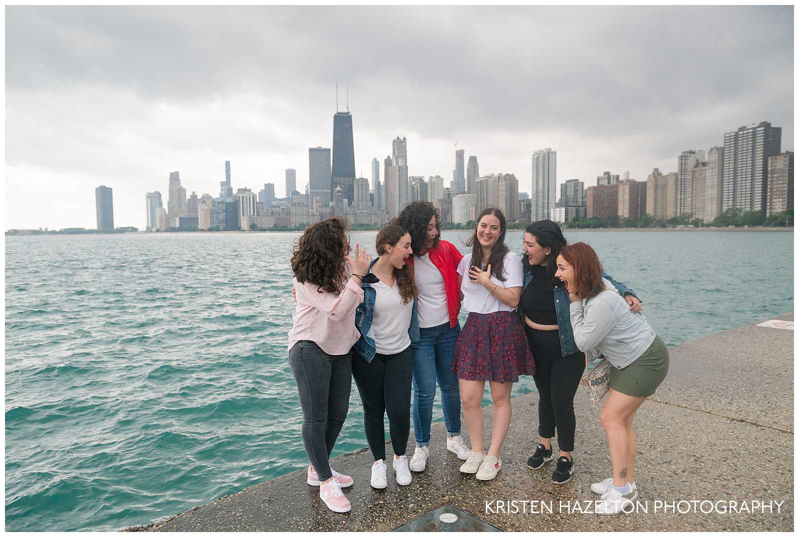 Newly engaged woman with friends on the North Avenue Beach concrete wavebreak