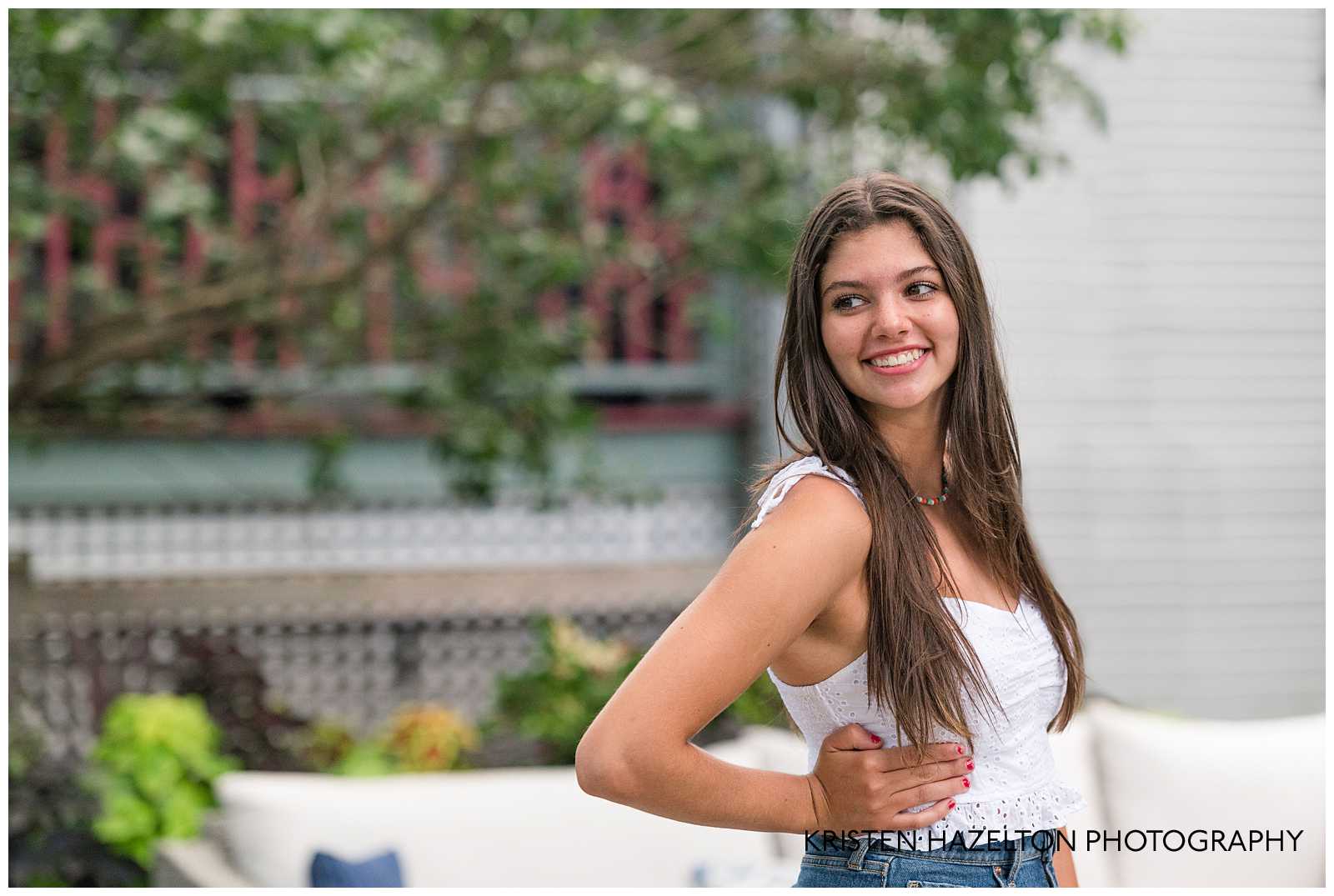 High school senior girl looking over her shoulder and smiling