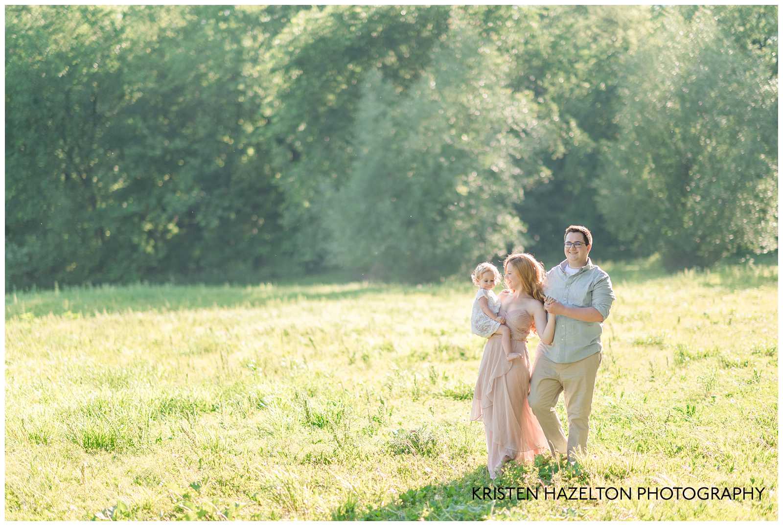 Family of three walking through a sunny meadow by Riverside, IL family photographer Kristen Hazelton