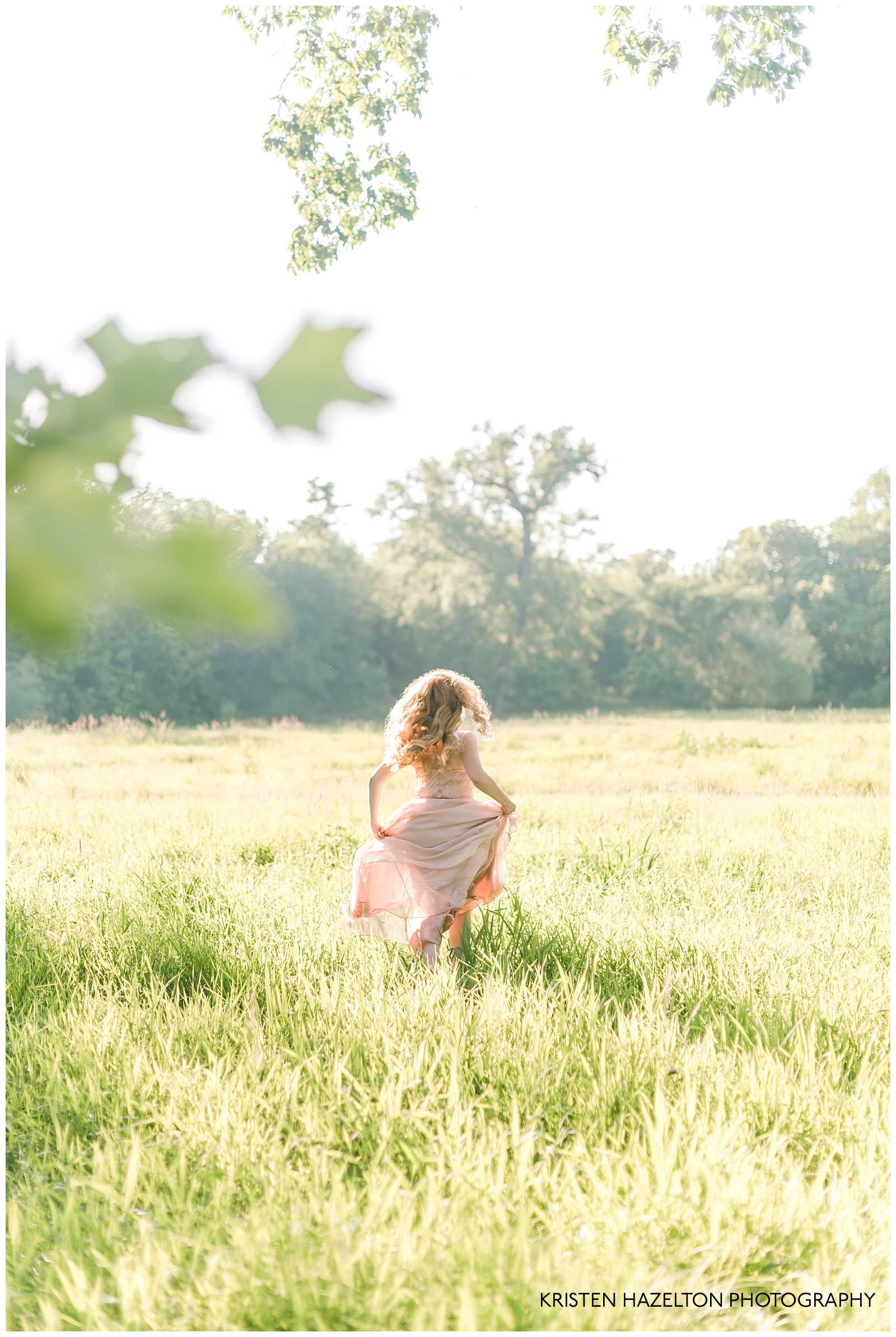 Redheaded woman running in a sunny meadow by Riverside, IL family photographer Kristen Hazelton