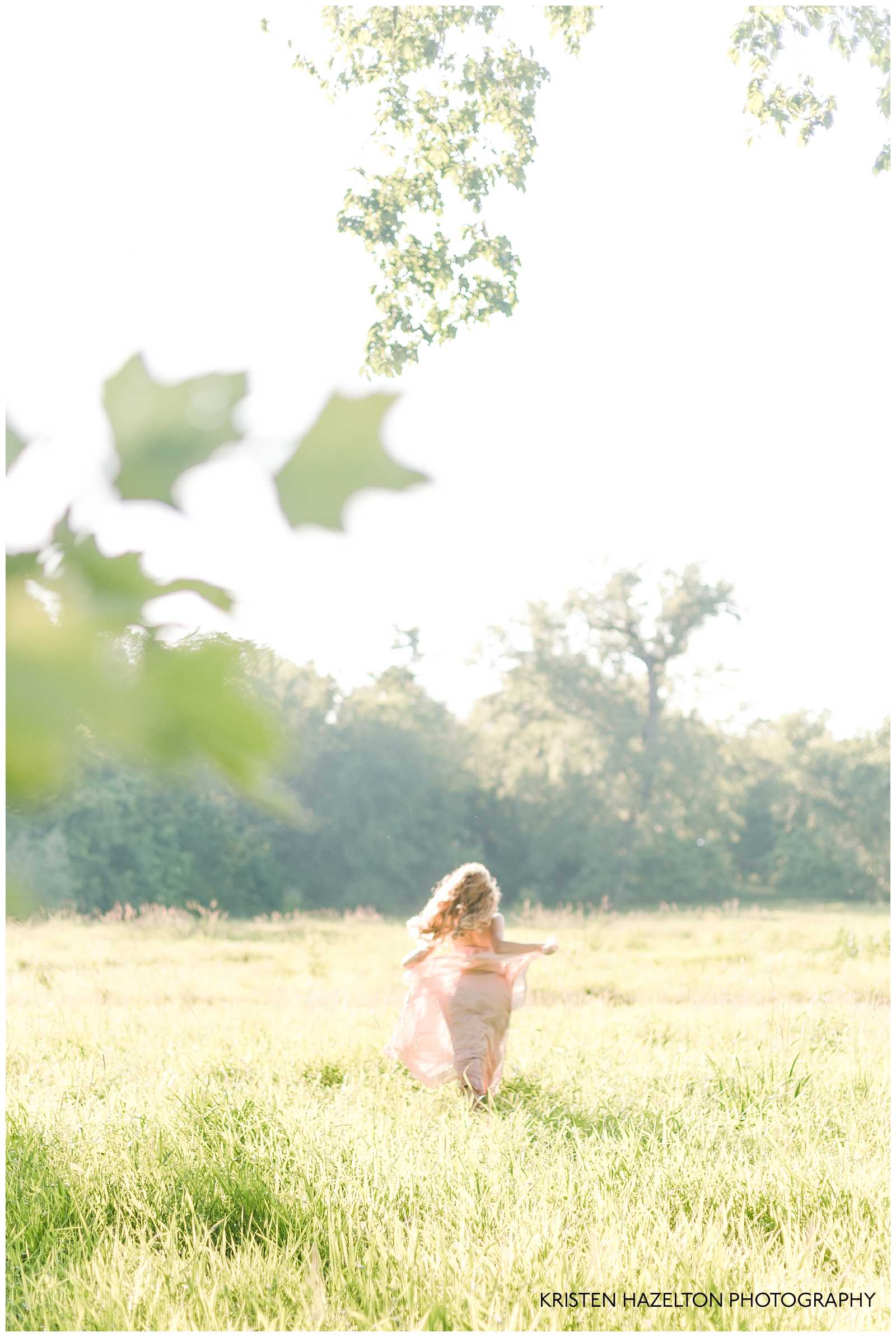 Out of focus photo of a redheaded woman running in a meadow