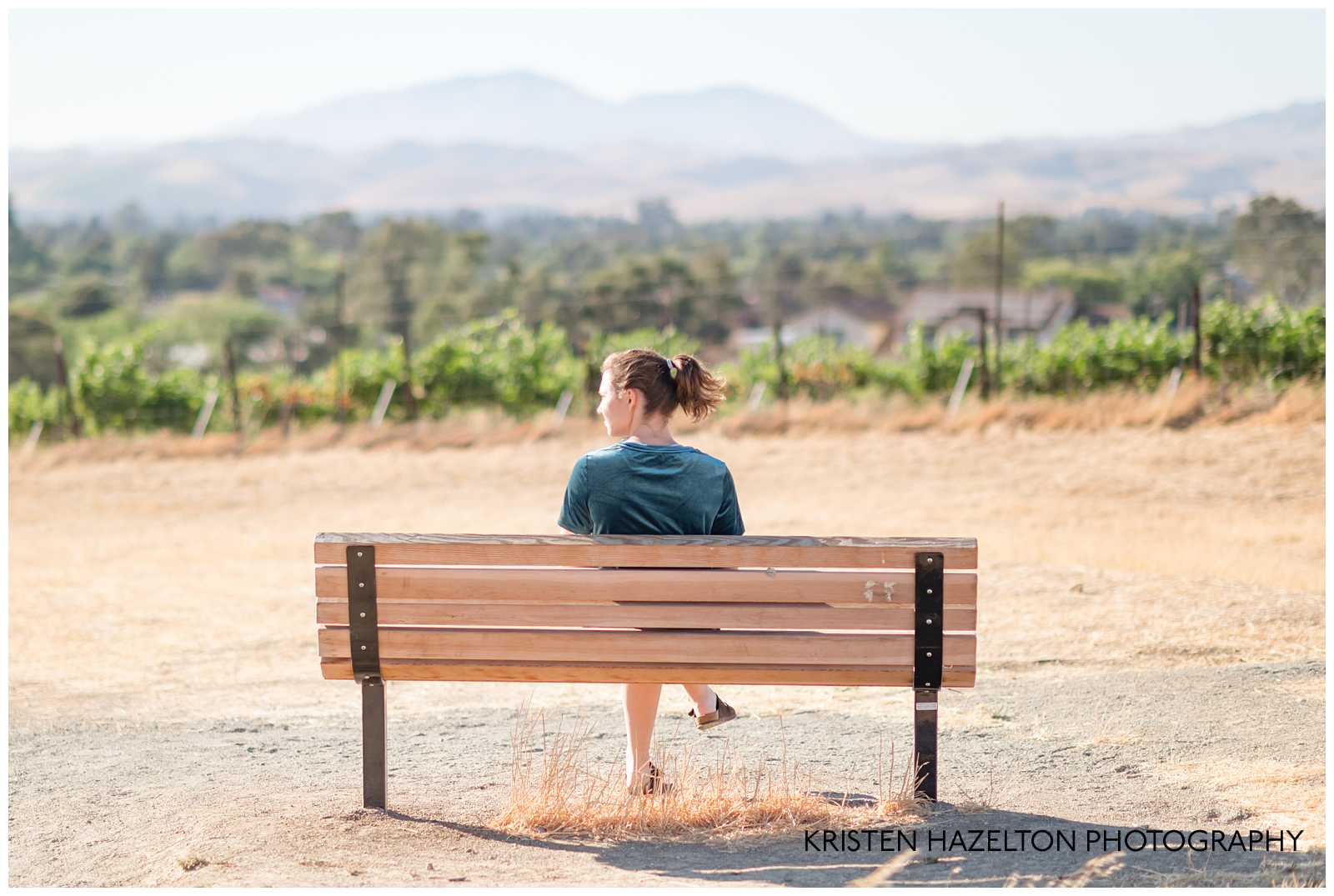 high school senior girl sitting on a bench overlooking the livermore valley
