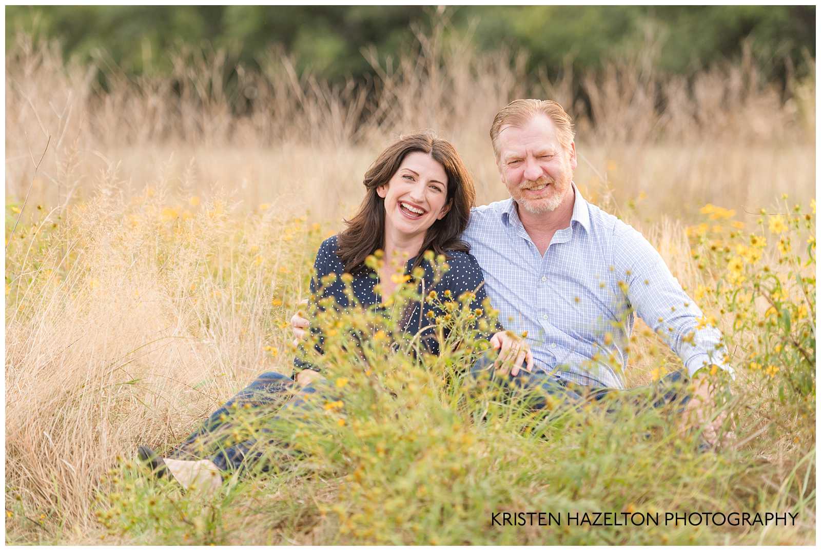 Man and woman sitting in a field laughing by Berwyn, IL photographer Kristen Hazelton