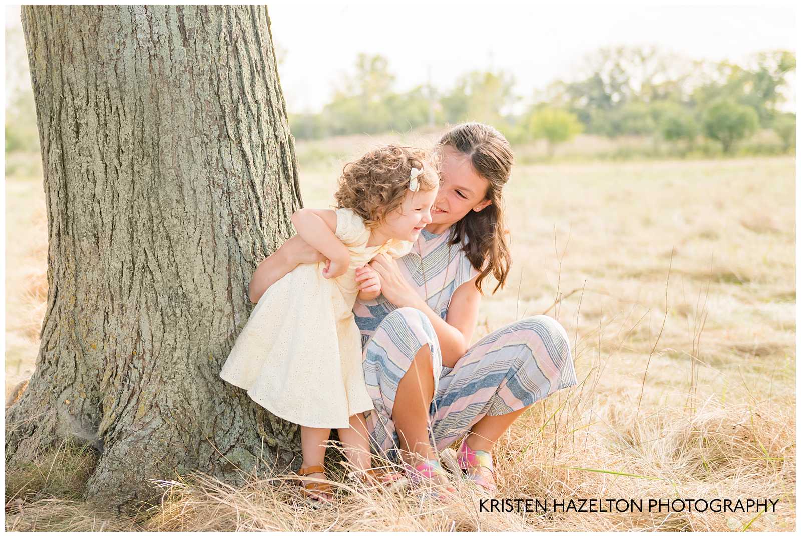 Big sister tickling her toddler sister by Elmwood Park, IL photographer Kristen Hazelton