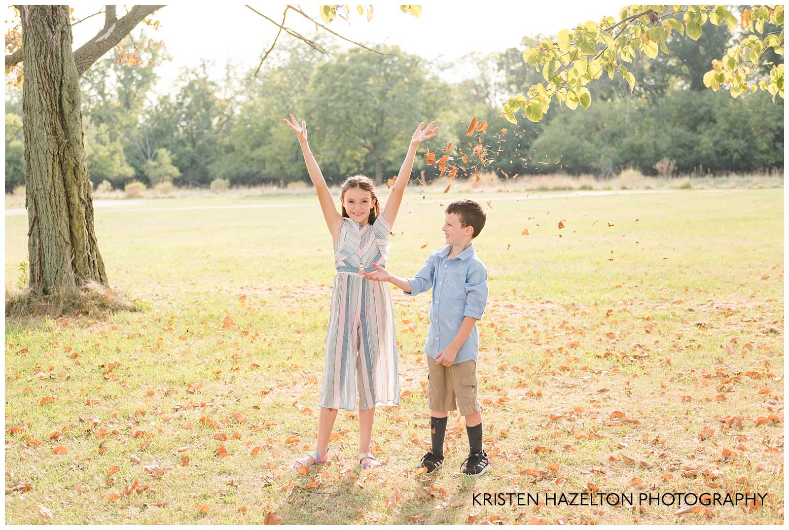 Boy and girl throwing leaves by Elmwood Park, IL photographer Kristen Hazelton