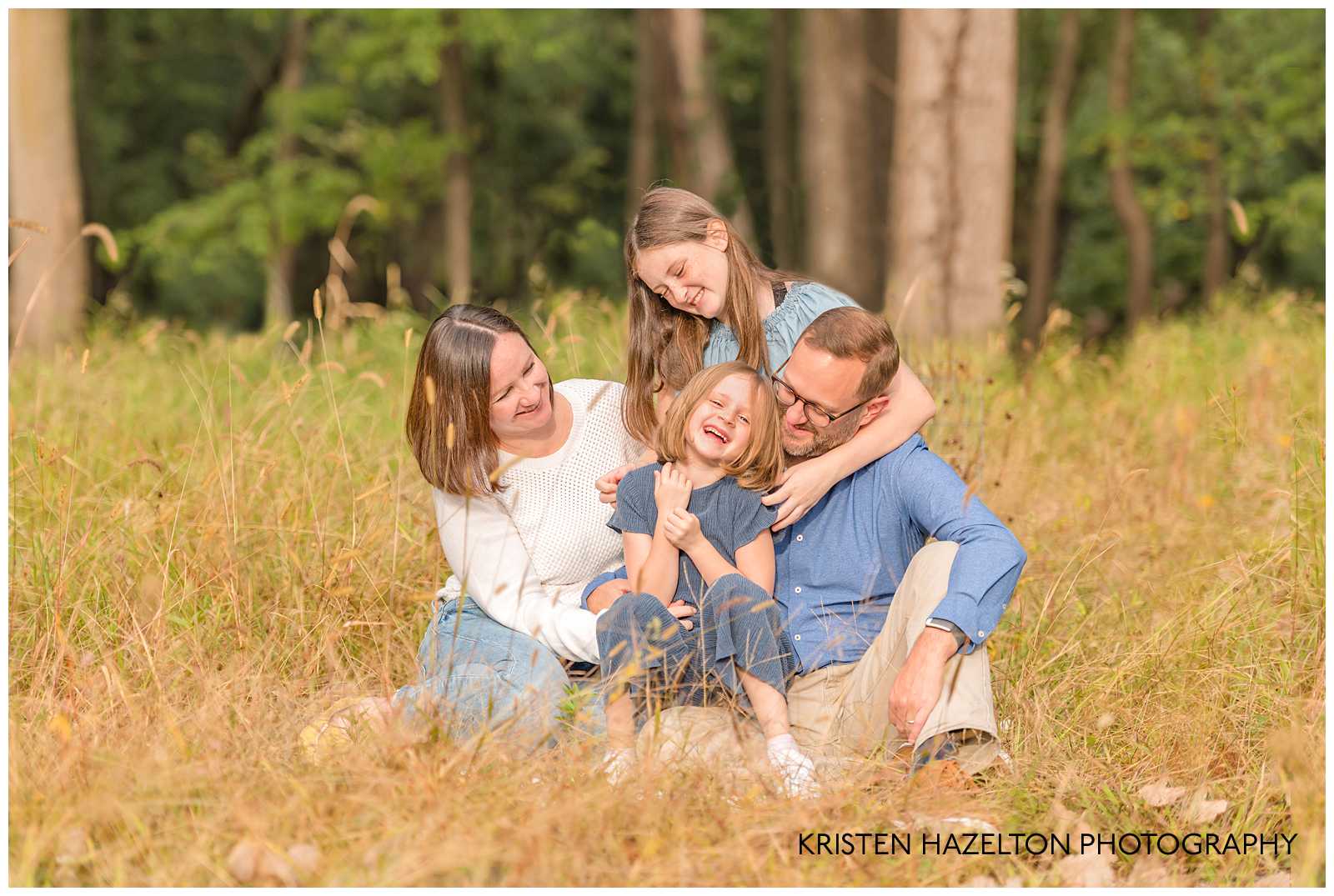 Family of four tickling their daughter in a field of cattails by River Forest, IL photographer Kristen Hazelton