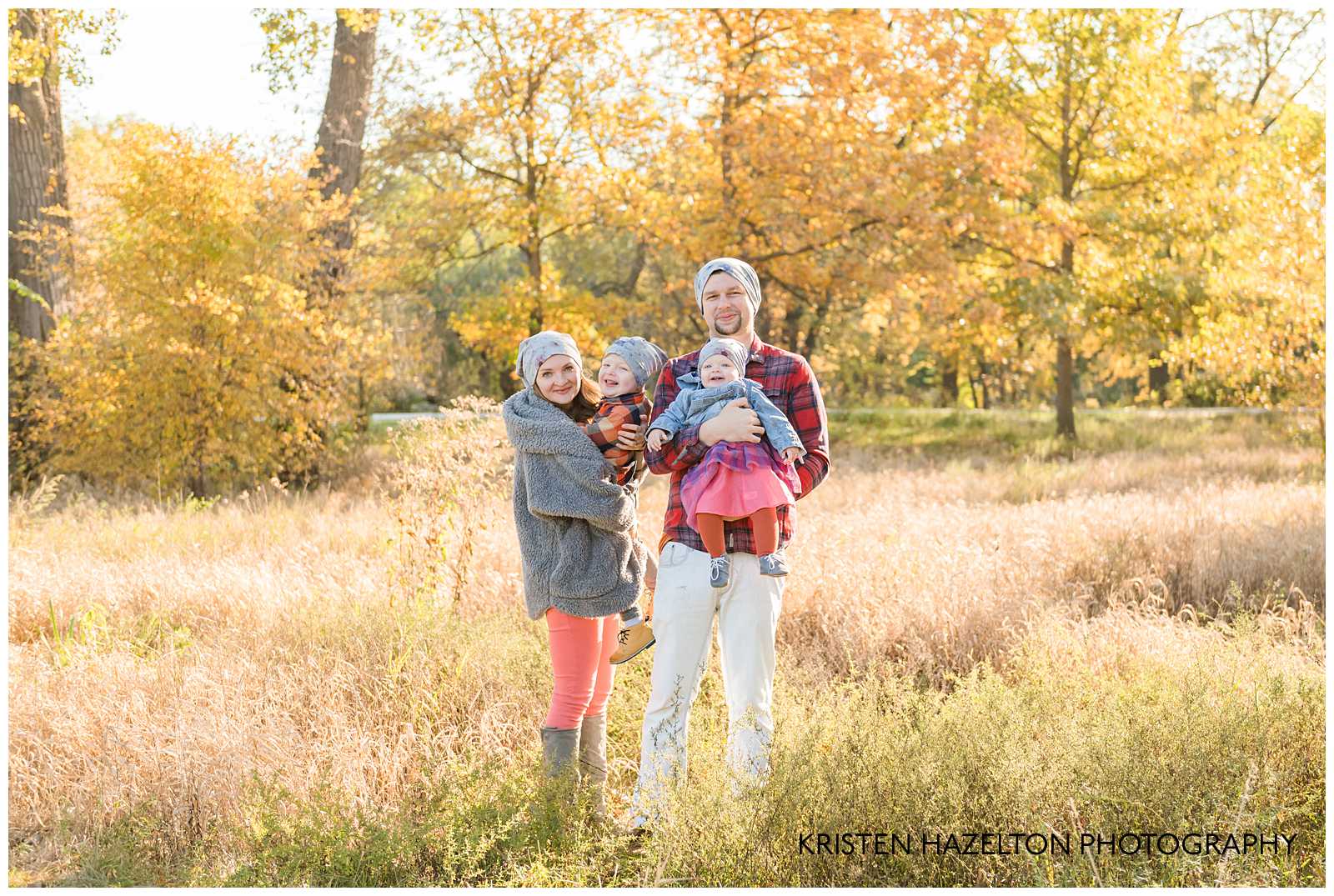 Family of four standing in a field by Cicero, IL photographer Kristen Hazelton