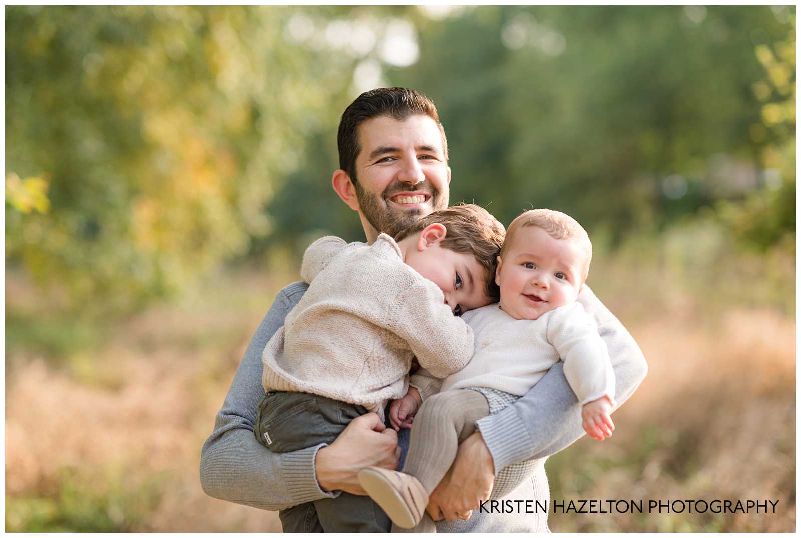 Dad smiling and holding his two young sons by Riverside, IL photographer Kristen Hazelton