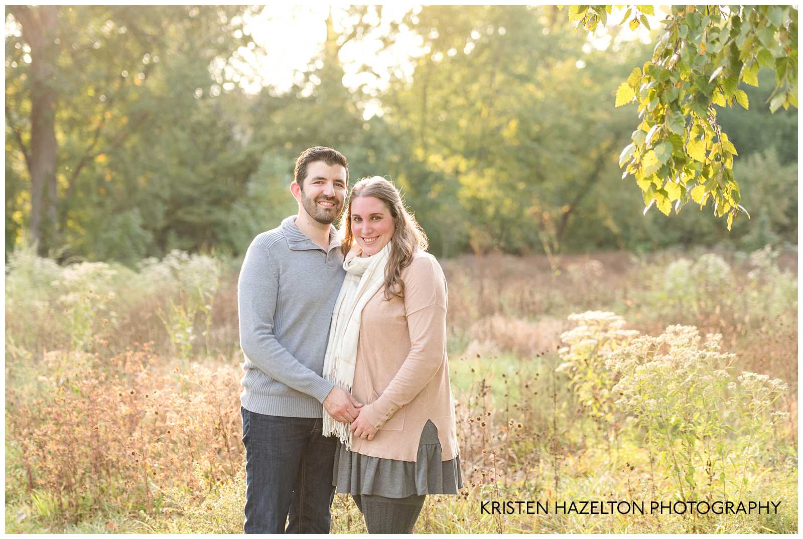 Man in gray sweater and woman in pink shirt with white scarf standing in a meadow by Riverside, IL photographer Kristen Hazelton