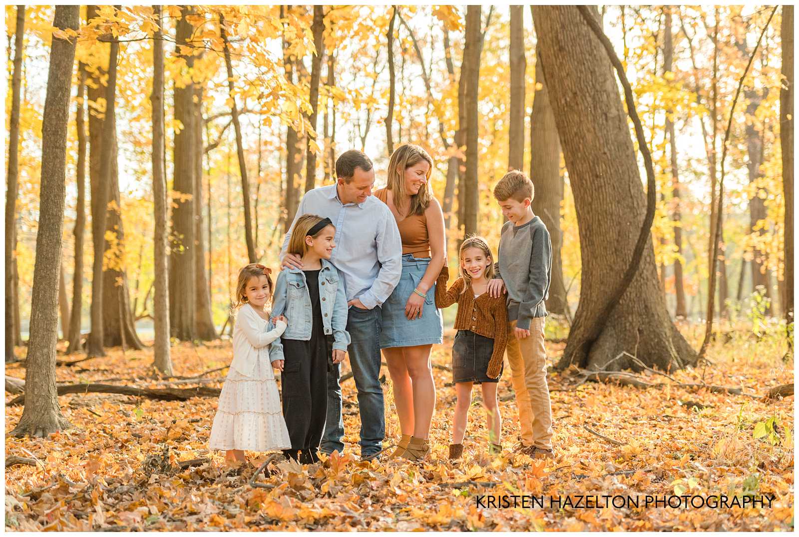 family of six looking in the fall woods at photographer Kristen Hazelton's River Forest IL Fall Mini Sessions