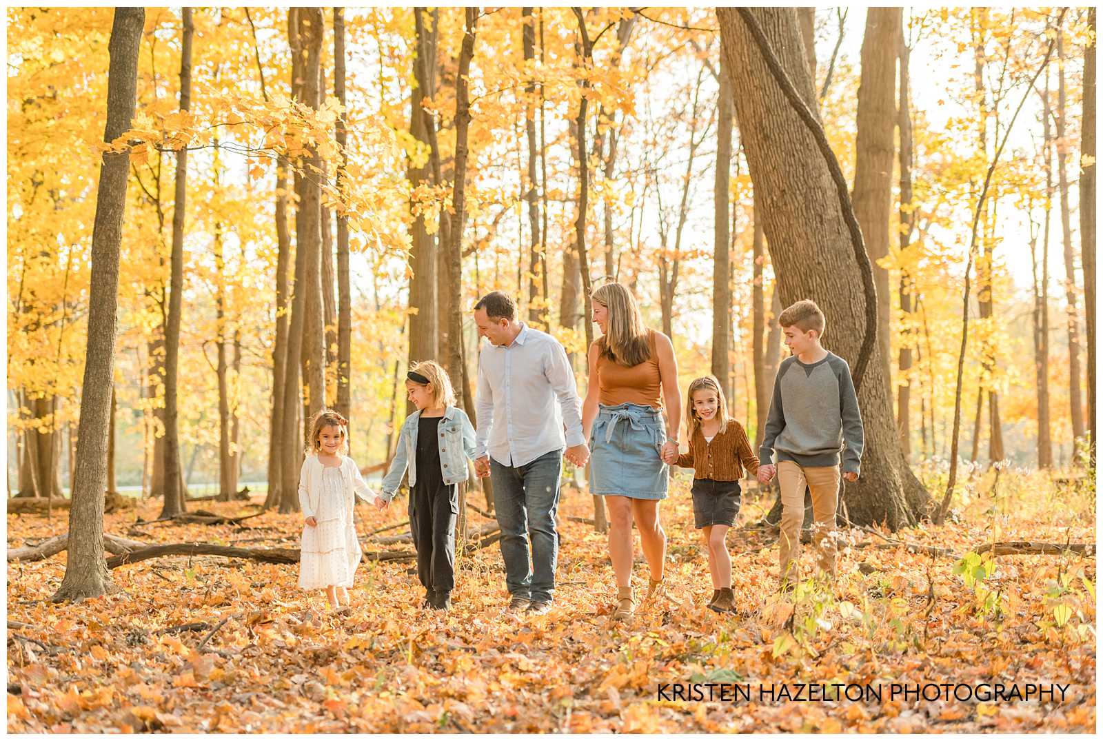 Family of six walking in the fall woods at photographer Kristen Hazelton's River Forest IL Fall Mini Sessions