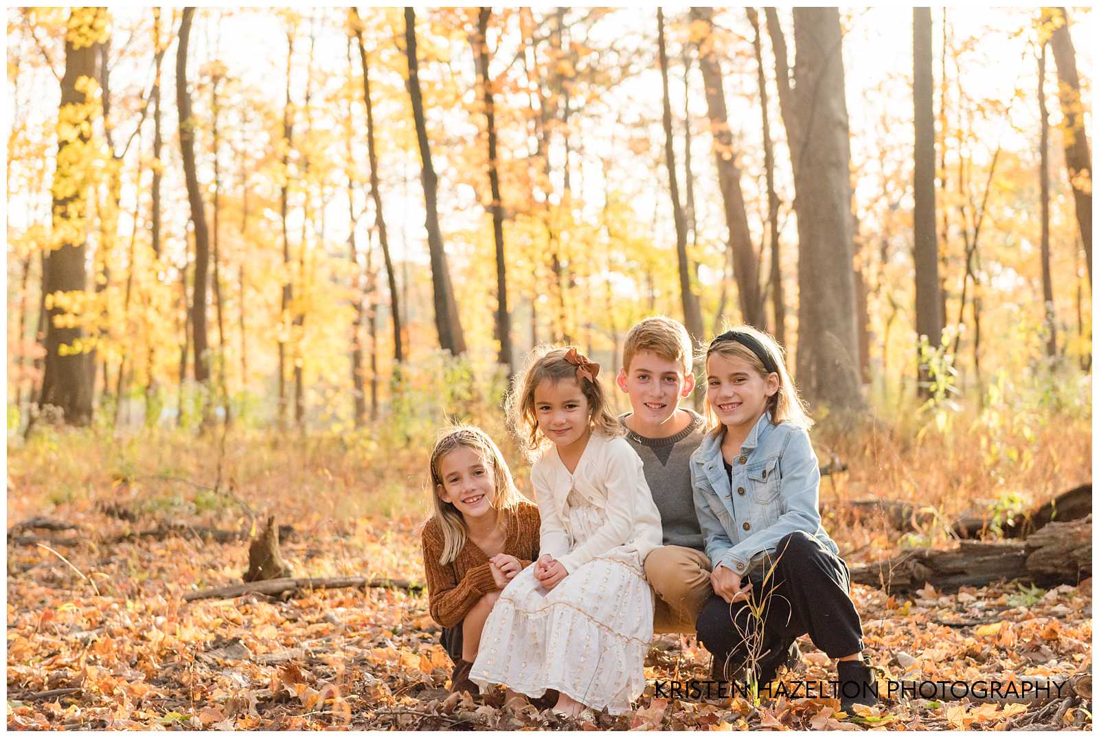 Four young brothers and sisters in the fall woods